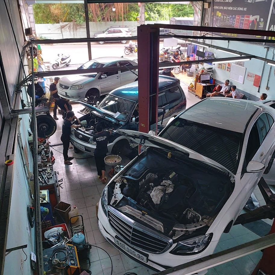 Gara đang sửa chữa ô tô, thợ làm việc với cầu nâng