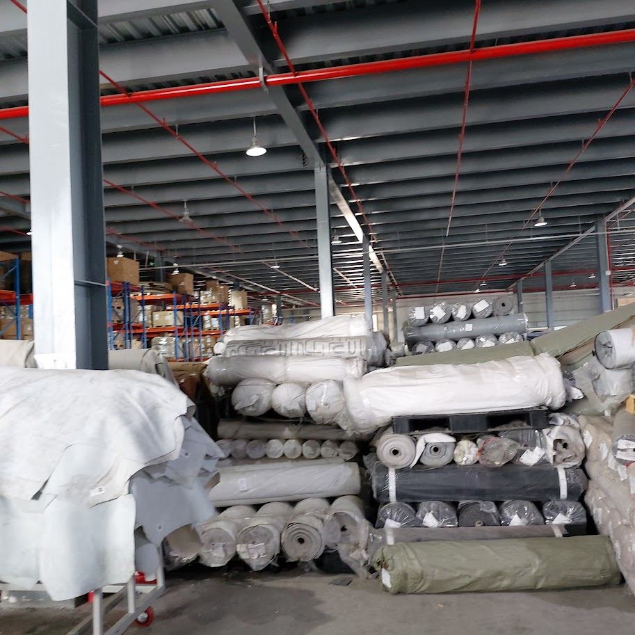 Kho vải cuộn xếp trên kệ sắt nhiều tầng trong nhà xưởng