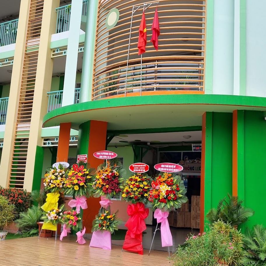 Cổng tòa nhà trường mầm non có hoa chúc mừng