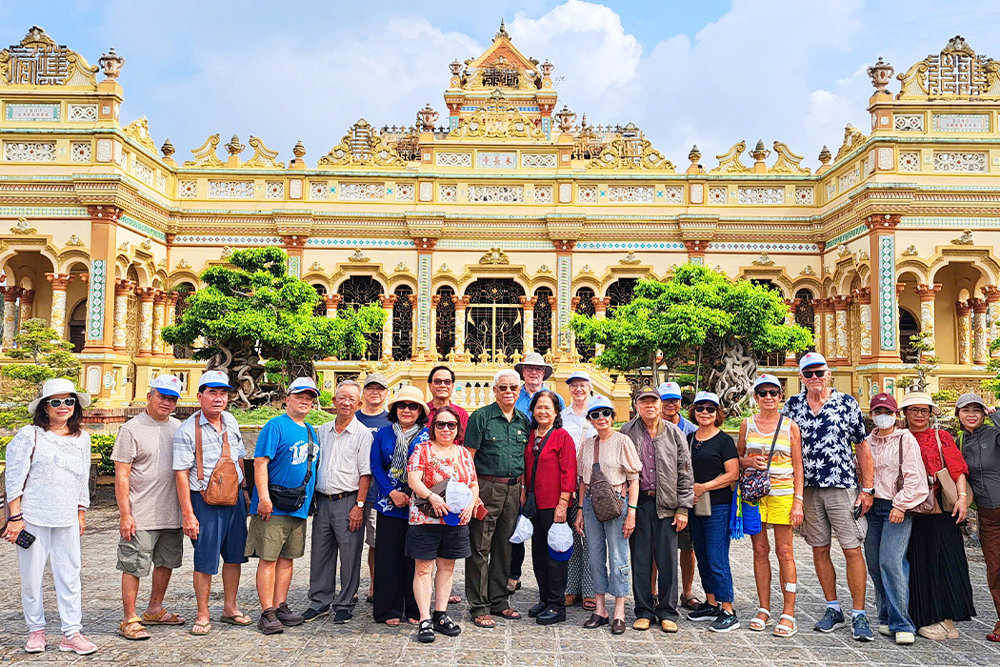 Đoàn khách trước chùa Vĩnh Tràng, ngôi chùa pha trộn kiến trúc Á - Âu.