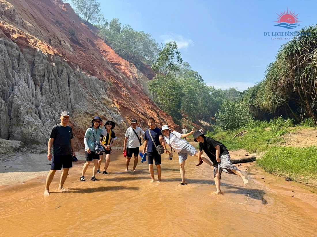 Du khách lội Suối Tiên Mũi Né với vách nhũ cát đỏ trắng đặc trưng hai bên dòng suối nông