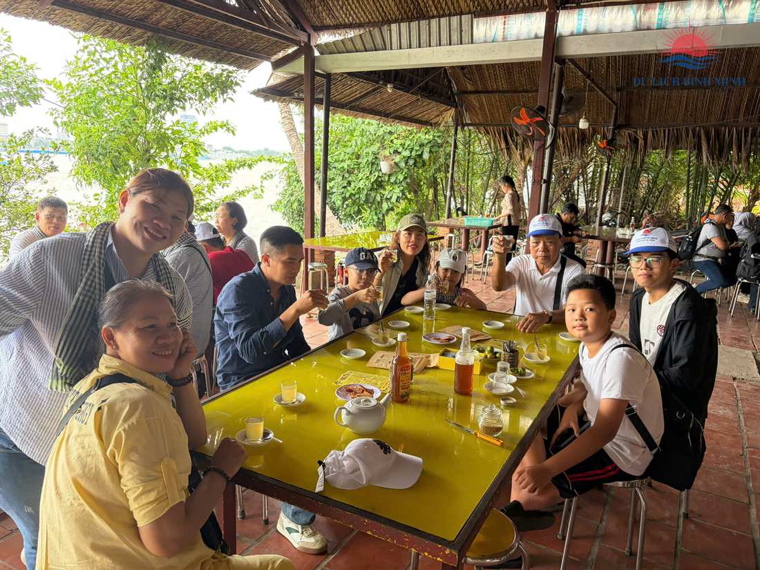 Đoàn khách nâng ly thưởng thức trà mật ong tắc tại trại nuôi ong ven sông trên cù lao Thới Sơn, Tiền Giang