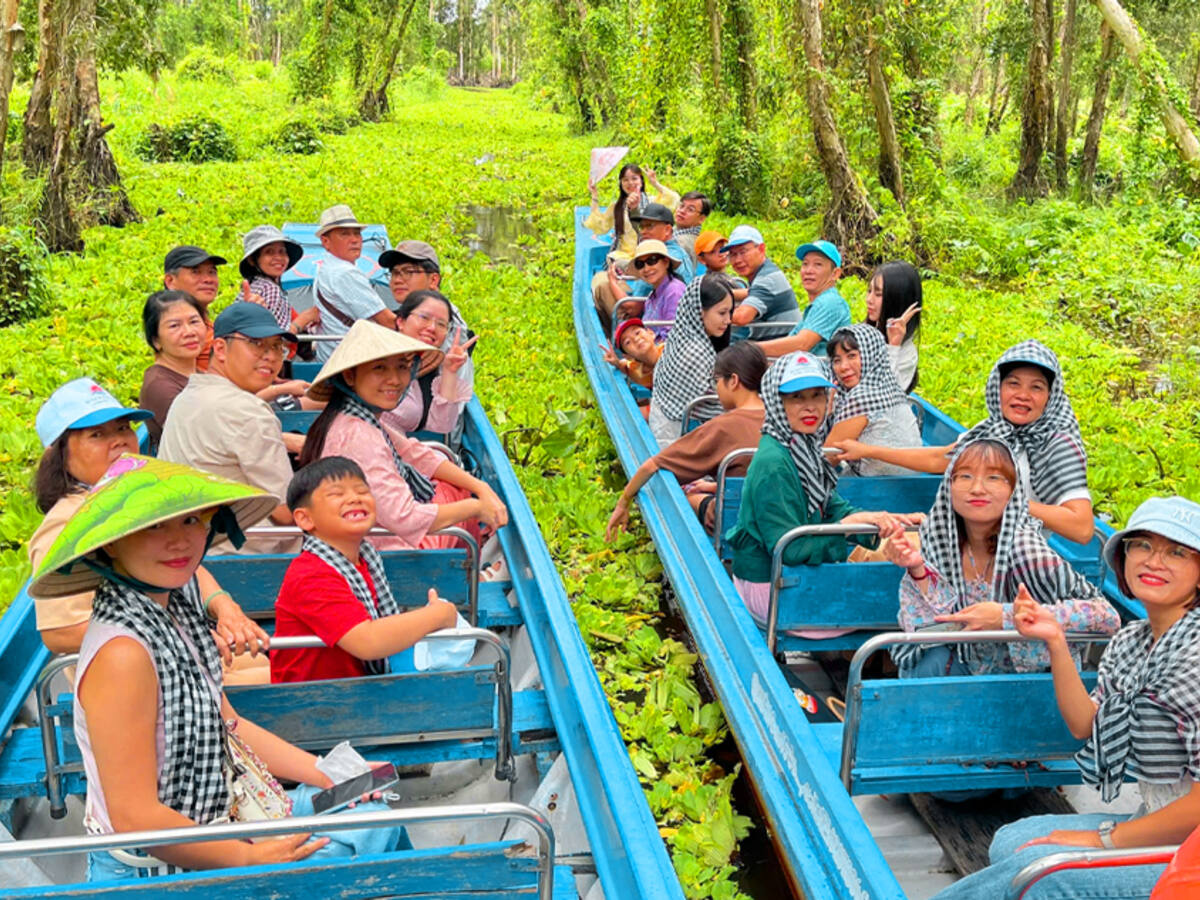 Đoàn khách đi xuồng trong rừng tràm Trà Sư