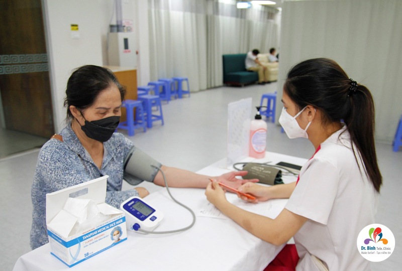 Bệnh nhân được điều dưỡng viên tiến thành đo huyết áp 