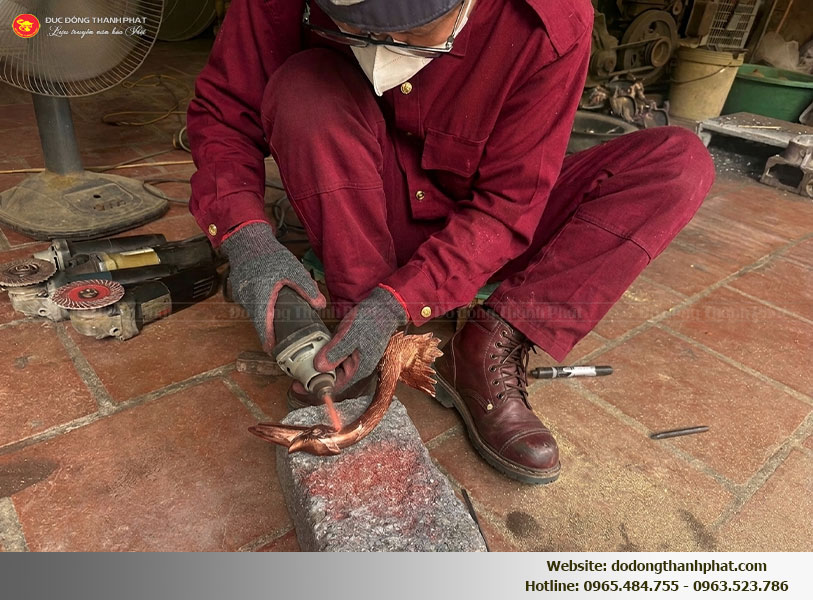 Nghệ nhân Đồ Đồng Thành Phát đang thực hiện công đoạn chạm khảm thủ công tỉ mỉ cho bộ tam sự đồng đỏ