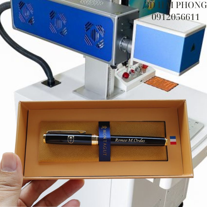 trên tay Bút ký Montagut khắc tên riêng và logo chụp cùng máy khắc khắc laser