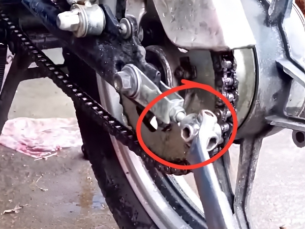 Dùng cờ lê đa năng nới lỏng ốc trục bánh sau