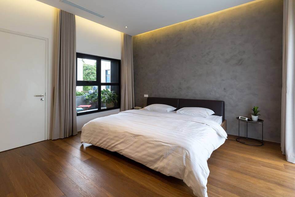 Không gian phòng ngủ với tường hiệu ứng bê tông mang lại cảm giác thoải mái.