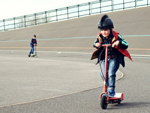 Đứng trên xe và điều khiển hướng di chuyển giúp trẻ học cách giữ trọng tâm cơ thể