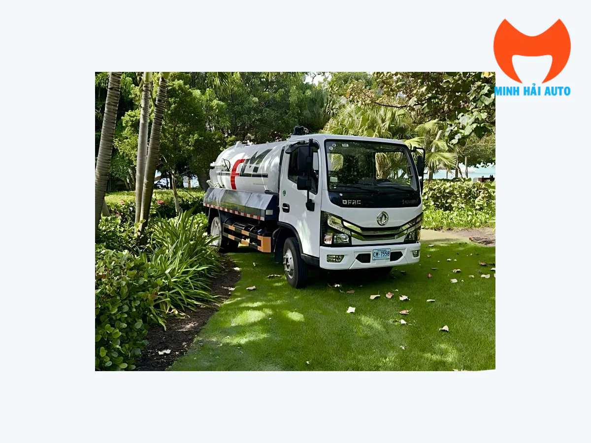 Xe hút chất thải Fulongma nền Dongfeng cabin trắng và bồn màu bạc trong khuôn viên cây xanh, nhìn từ góc trước ba phần tư