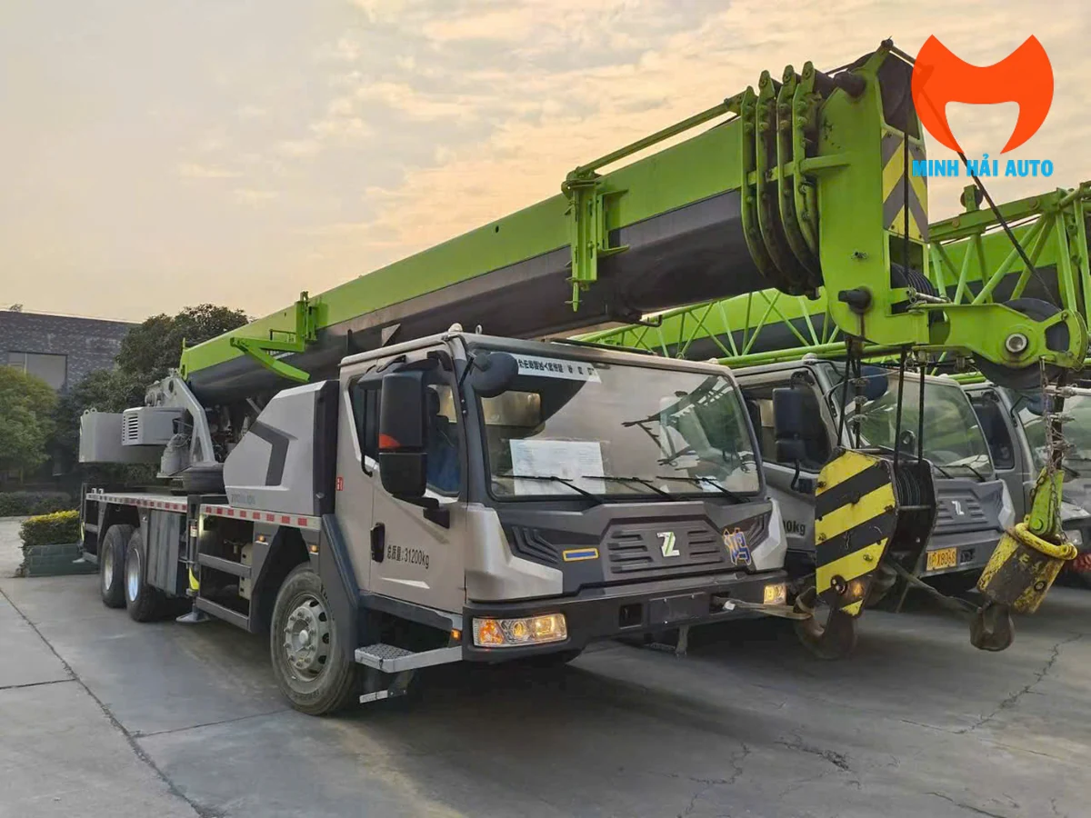 Xe cẩu bánh lốp Zoomlion ba trục cần màu xanh lá, nhìn chếch góc 3/4 phía trước bên phải