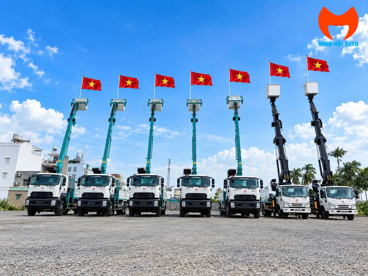 Bảy xe ô tô nâng người Minh Hải Auto xếp hàng, cần nâng dựng cao gắn cờ Việt Nam