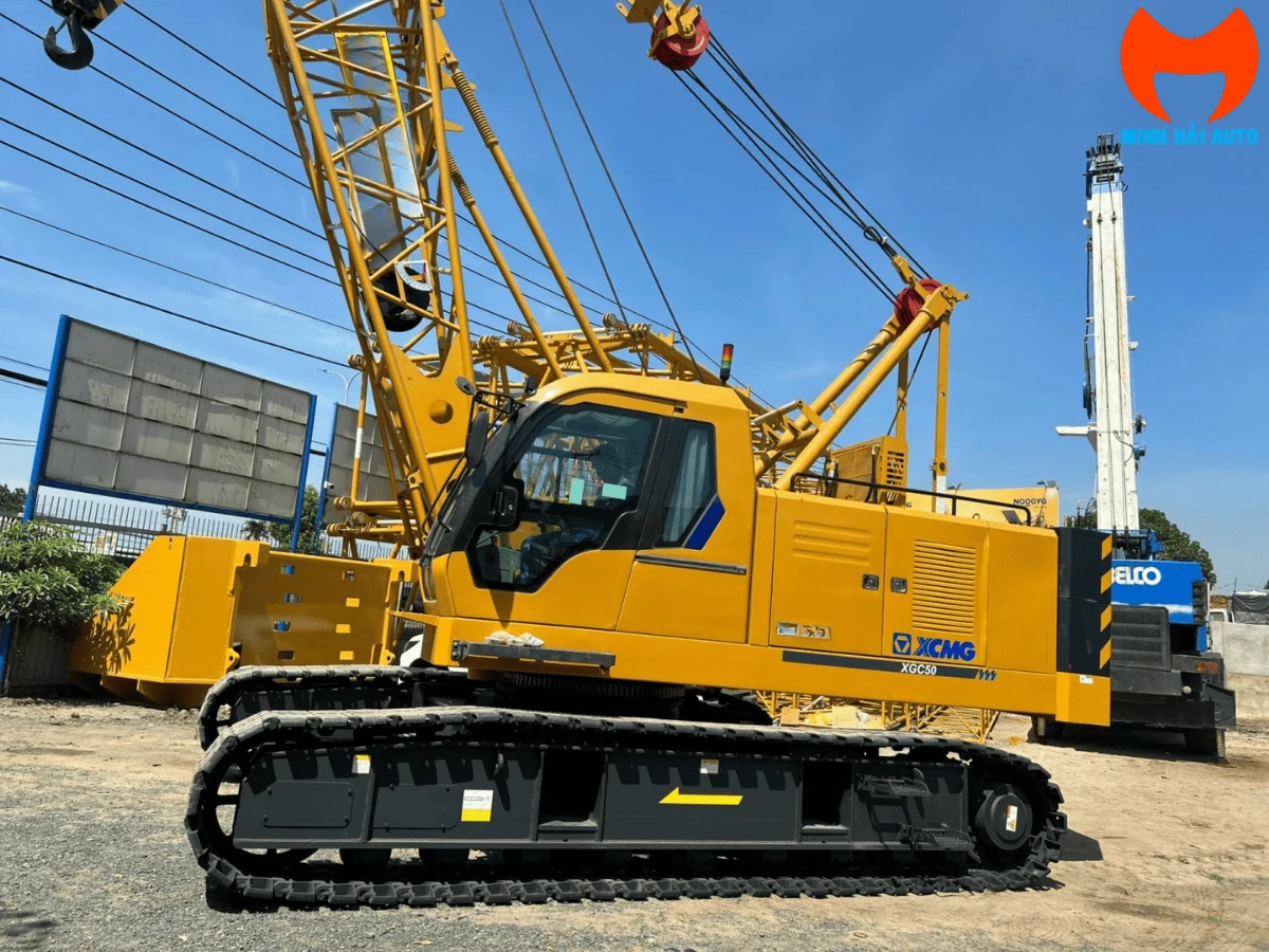 Cẩu bánh xích XCMG XGC50 màu vàng nhìn ngang, nhãn model XGC50 trên vỏ máy, cần lattice dựng phía sau