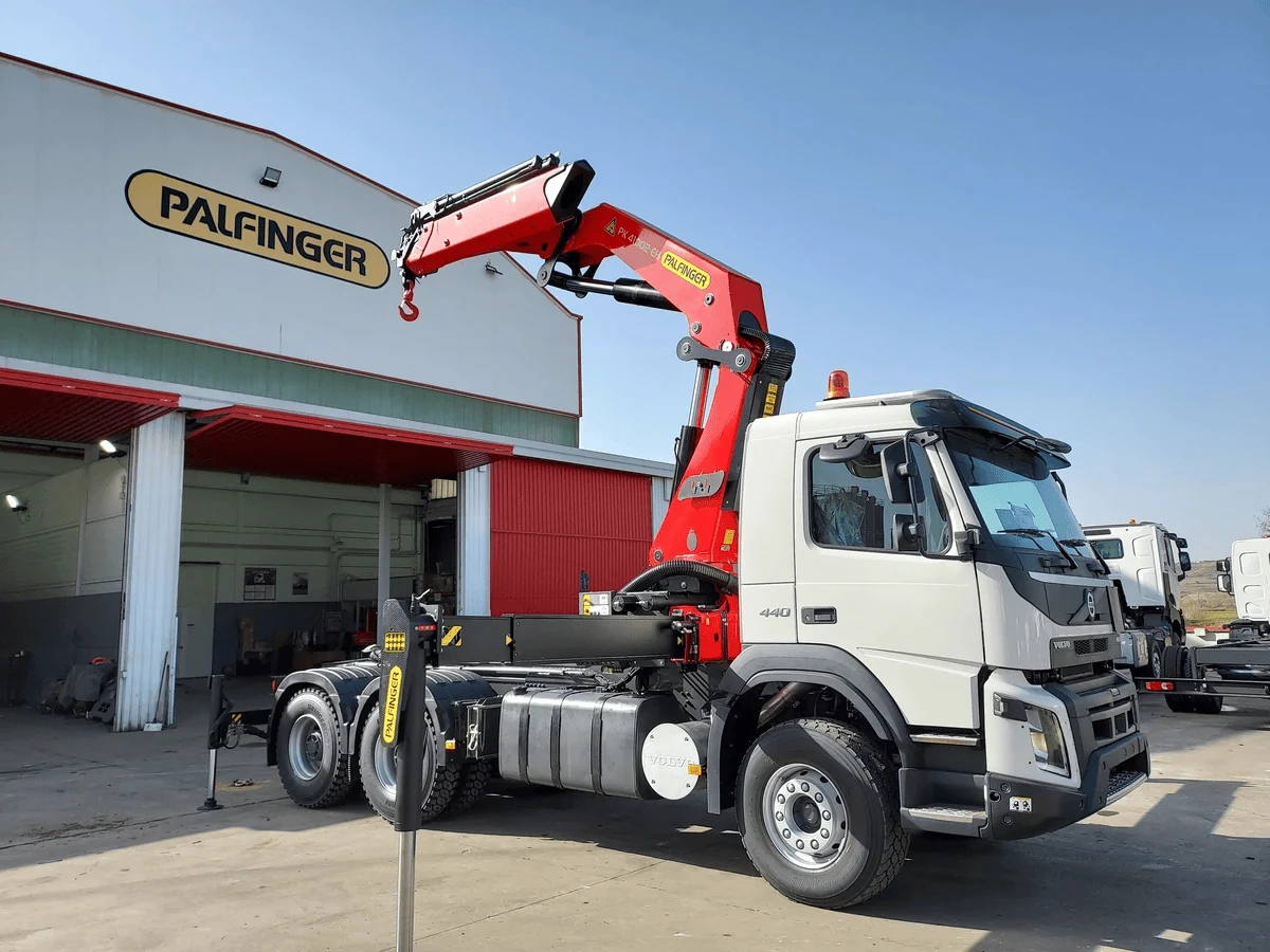 Cẩu gập khúc Palfinger màu đỏ lắp sau cabin xe tải trắng, cần gập gọn, chụp tại xưởng lắp đặt