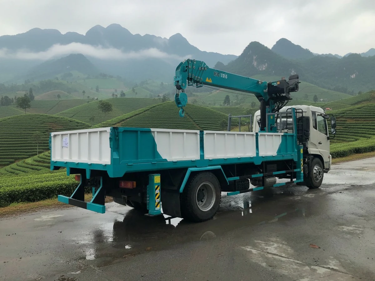 Cẩu Hyundai Everdigm HLC-7016 màu xanh ngọc lắp sau cabin xe tải thùng lửng, nhãn model HLC-7016 đọc rõ trên thân cần