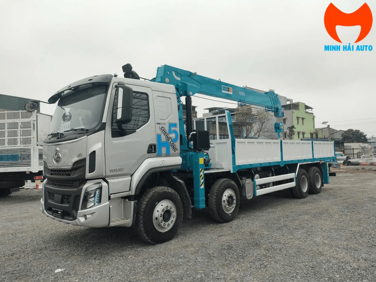 Xe tải Chenglong H5 bốn chân cabin bạc gắn cẩu Hyundai Everdigm HLC-12015 màu xanh, thùng lửng, nhìn chéo từ phía trước