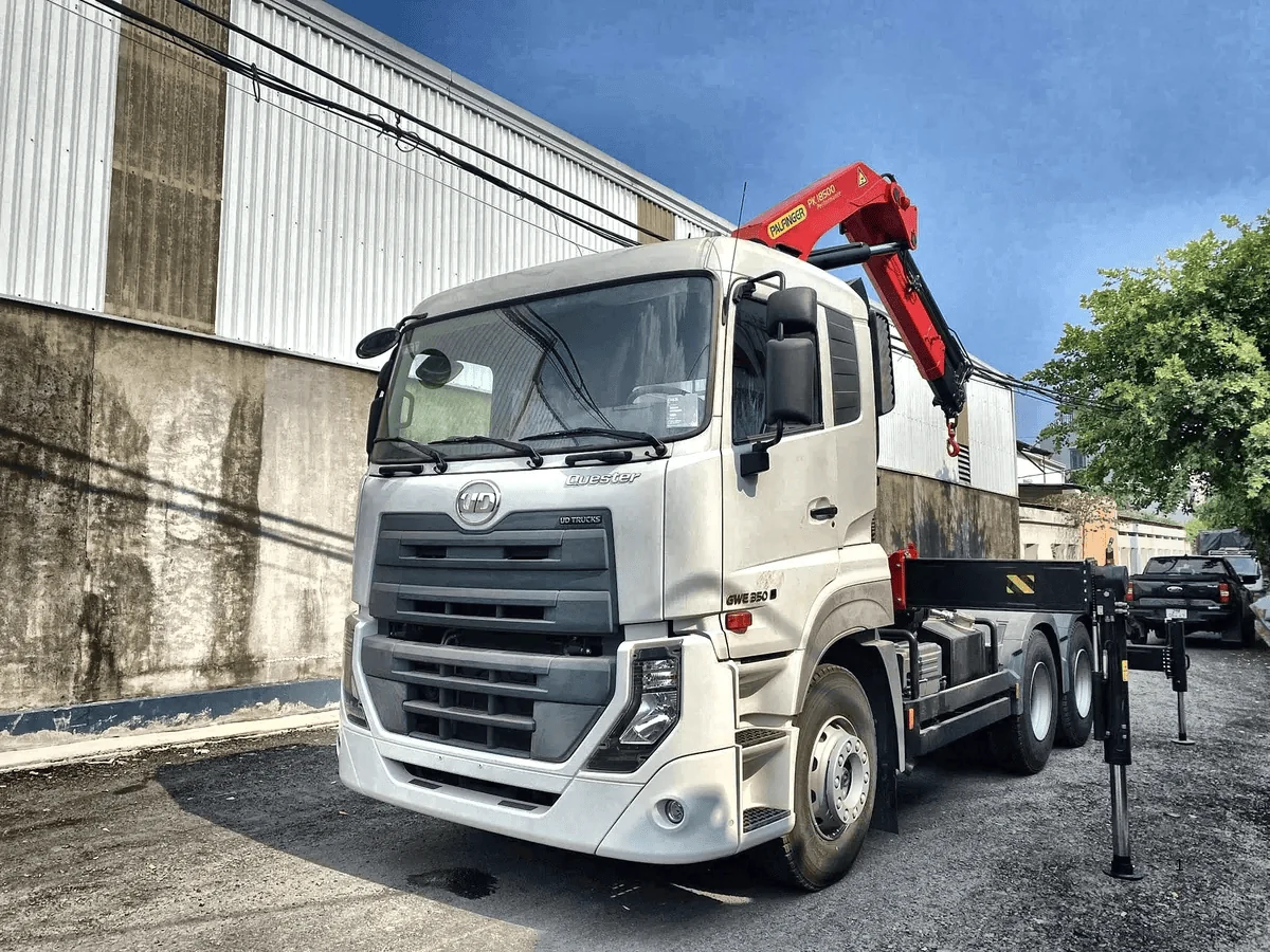 Đầu kéo UD Quester GWE 350 màu trắng ba trục, cẩu gập Palfinger đỏ gập gọn sau ca-bin, chụp góc trước chếch bên trái