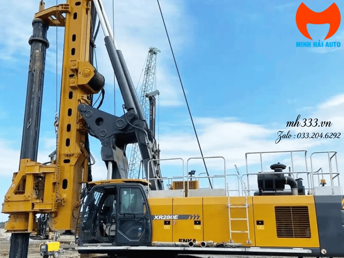 Máy khoan cọc nhồi XCMG XR280E màu vàng dựng cột buồm tại công trường, nhãn XR280E trên thân máy, cần cẩu bánh xích phía sau