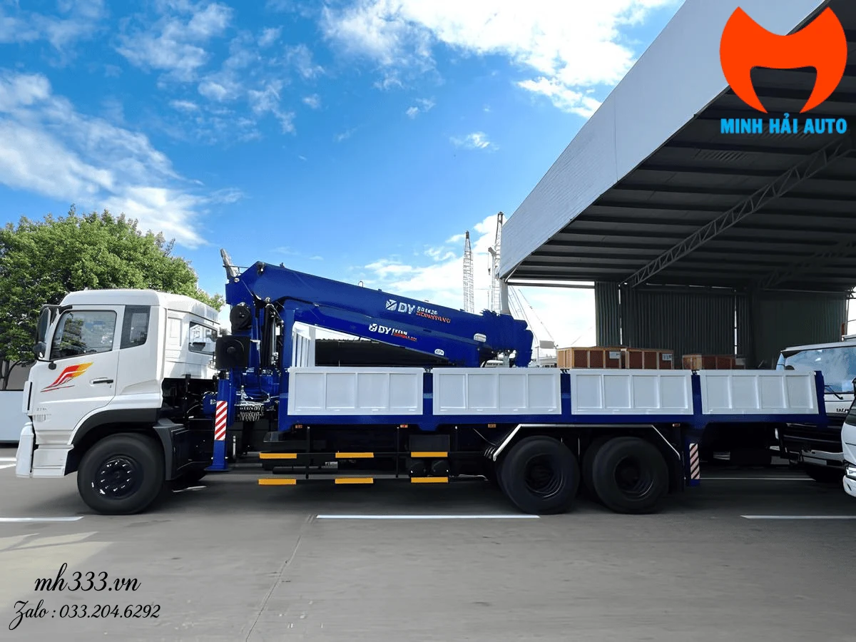 Cẩu Dongyang màu xanh dương nhìn ngang, nhãn DY SS2036 đọc rõ trên thân cần, xe tải Dongfeng ba chân thùng lửng trắng