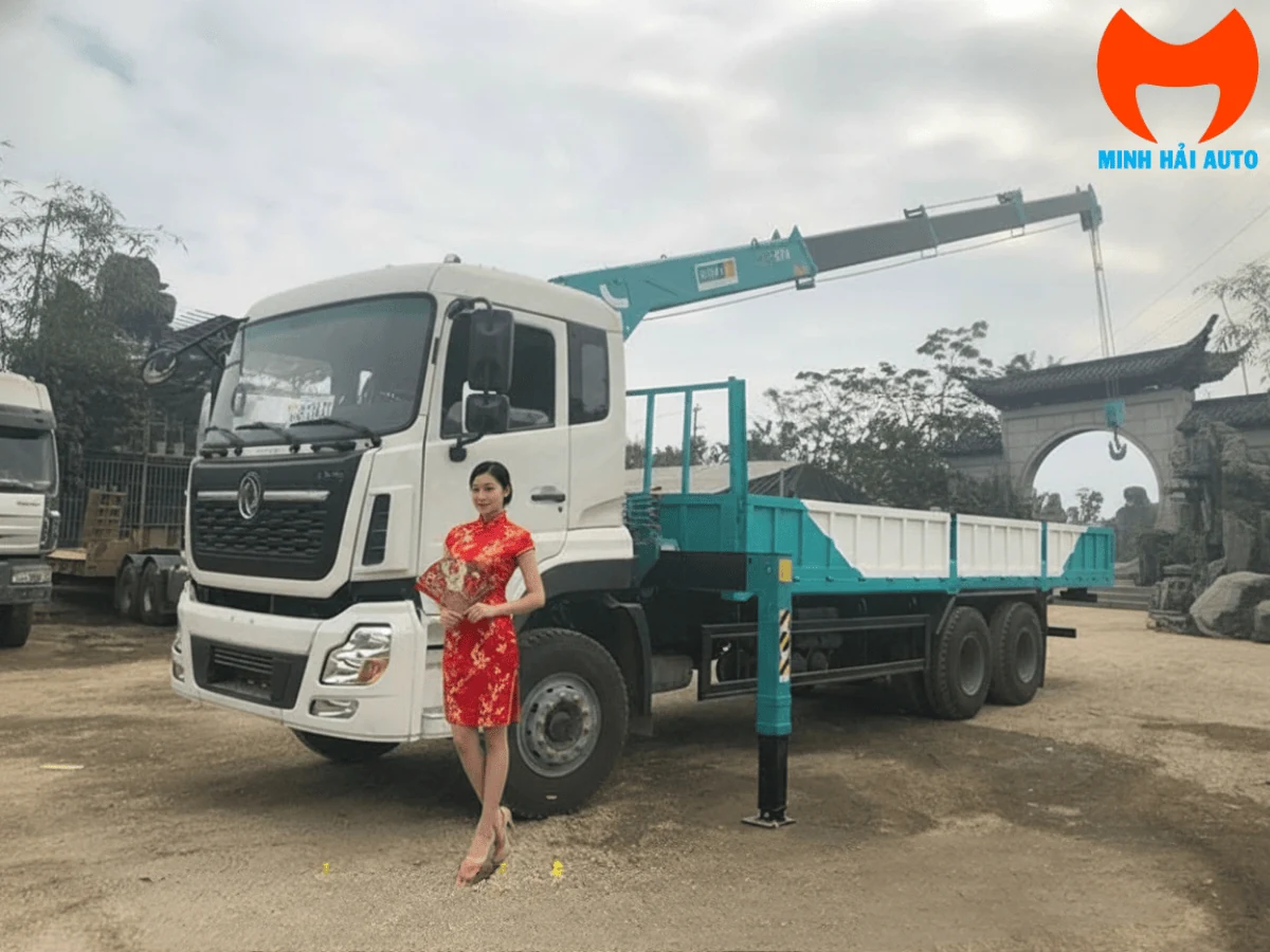 Toàn cảnh xe tải Dongfeng ba chân cabin trắng gắn cẩu xanh ngọc đỗ tại bãi xe, cần cẩu duỗi cao