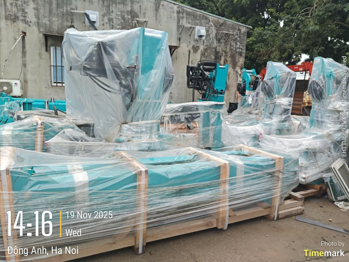 Nhiều cụm cẩu Hyundai Everdigm màu xanh ngọc bọc nilon và đóng kiện gỗ xếp thành hàng tại kho