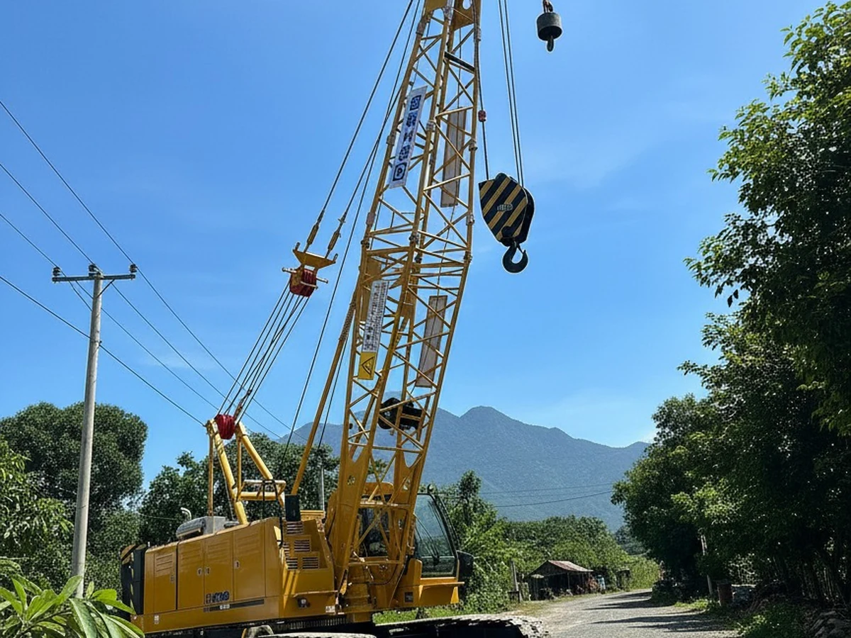 Cẩu bánh xích XCMG XGC50 dựng cần lattice trên đường công trường, móc và puly treo ở đầu cần