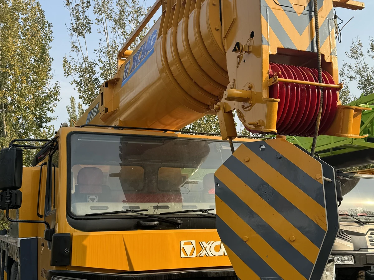 Cận cảnh đầu cần bảy đoạn và cụm tang tời màu đỏ của xe cẩu XCMG QY110KH, móc cẩu treo phía dưới
