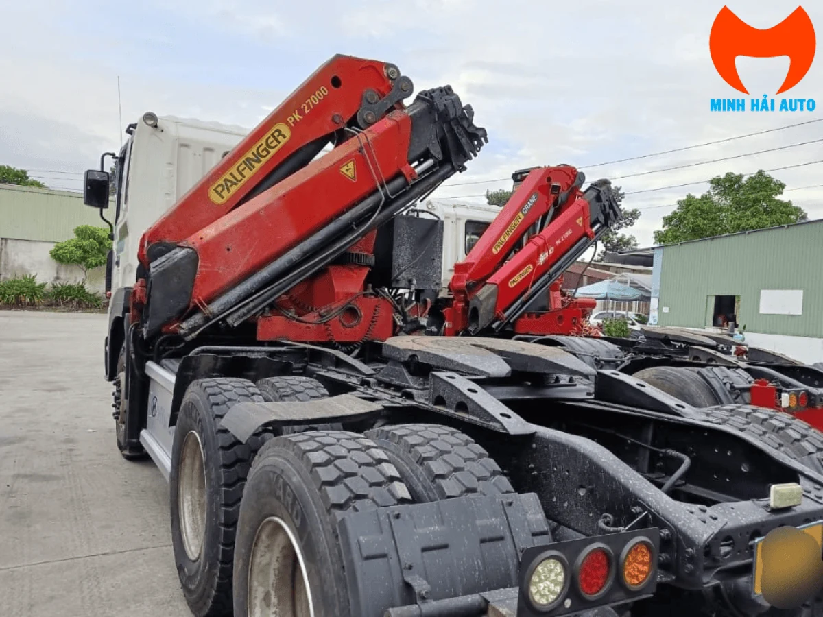 Cận cảnh nhãn PALFINGER PK 27000 màu vàng trên thân cần cẩu màu đỏ, phía sau là mâm kéo của đầu kéo