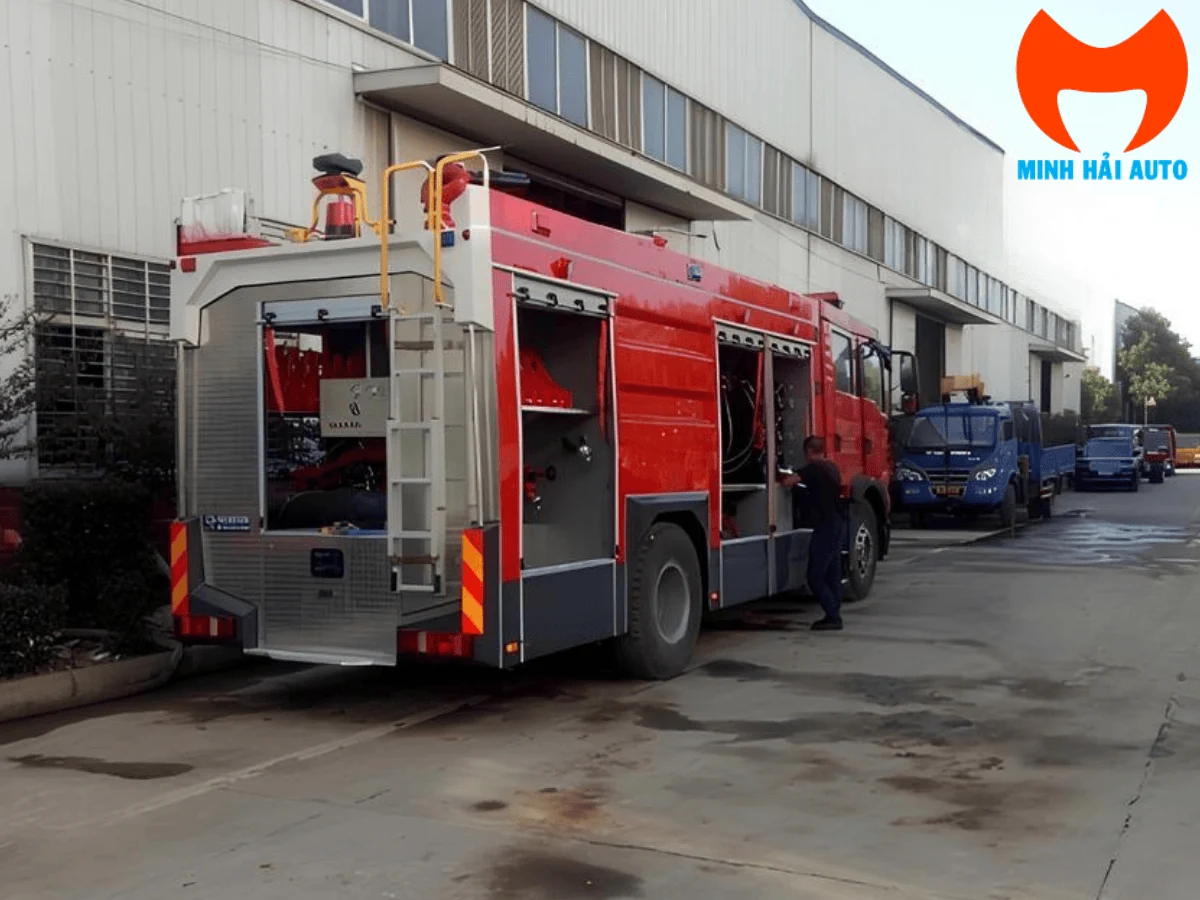 Góc sau xe chữa cháy bột khô HOWO 7 khối tại nhà máy, thấy khoang sau mở và thang leo