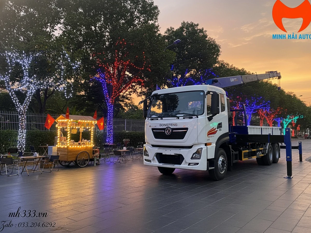 Xe tải Dongfeng bốn chân cabin trắng gắn cẩu tự hành thùng lửng, chân chống hạ, chụp lúc hoàng hôn trên quảng trường