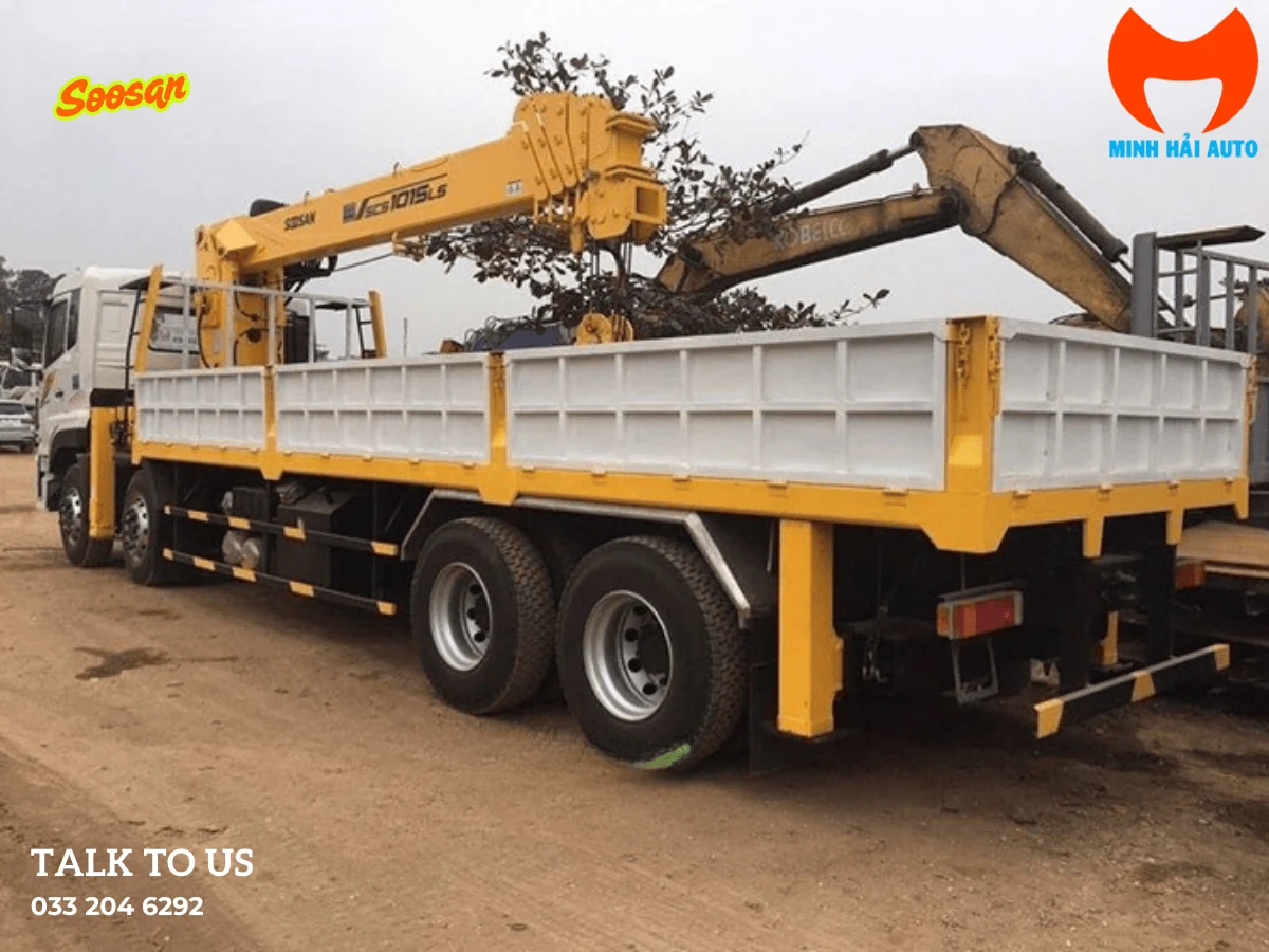 Xe tải cabin trắng gắn cẩu Soosan màu vàng, nhãn SCS1015LS trên thân cần, thùng lửng trắng vàng