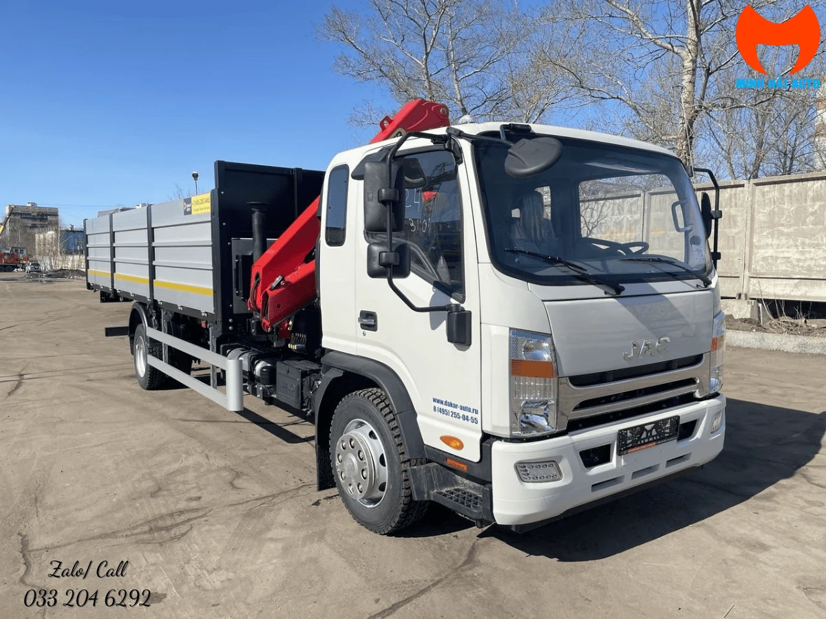 Xe tải JAC gắn cẩu gập Palfinger chụp góc trước chếch phải tại bãi xe, thùng lửng thành nhôm và cần cẩu đỏ gập gọn