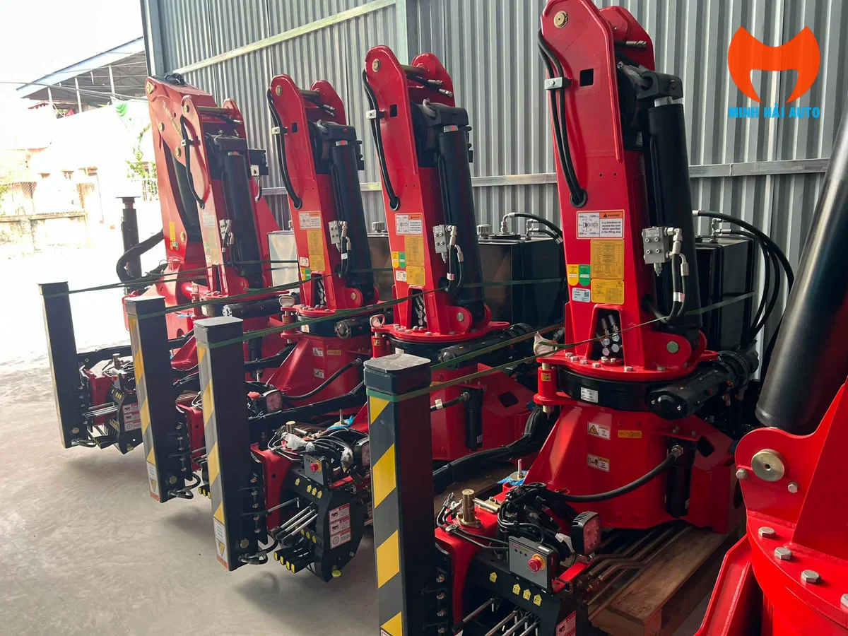 Các bộ cẩu gập màu đỏ cùng chân chống và đường ống thủy lực