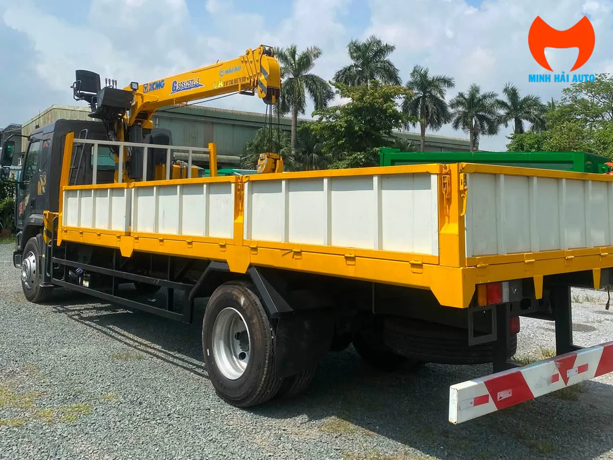 Xe Chenglong M3 gắn cẩu XCMG nhìn từ phía sau bên trái, thùng lửng vàng và cần cẩu thu gọn