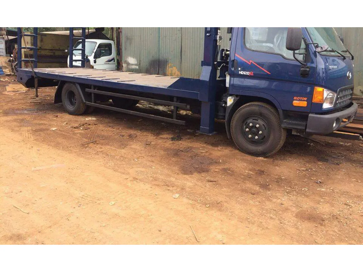 Xe nâng đầu Hyundai HD120SL màu xanh với sàn chở máy dài và cột thủy lực nâng đầu