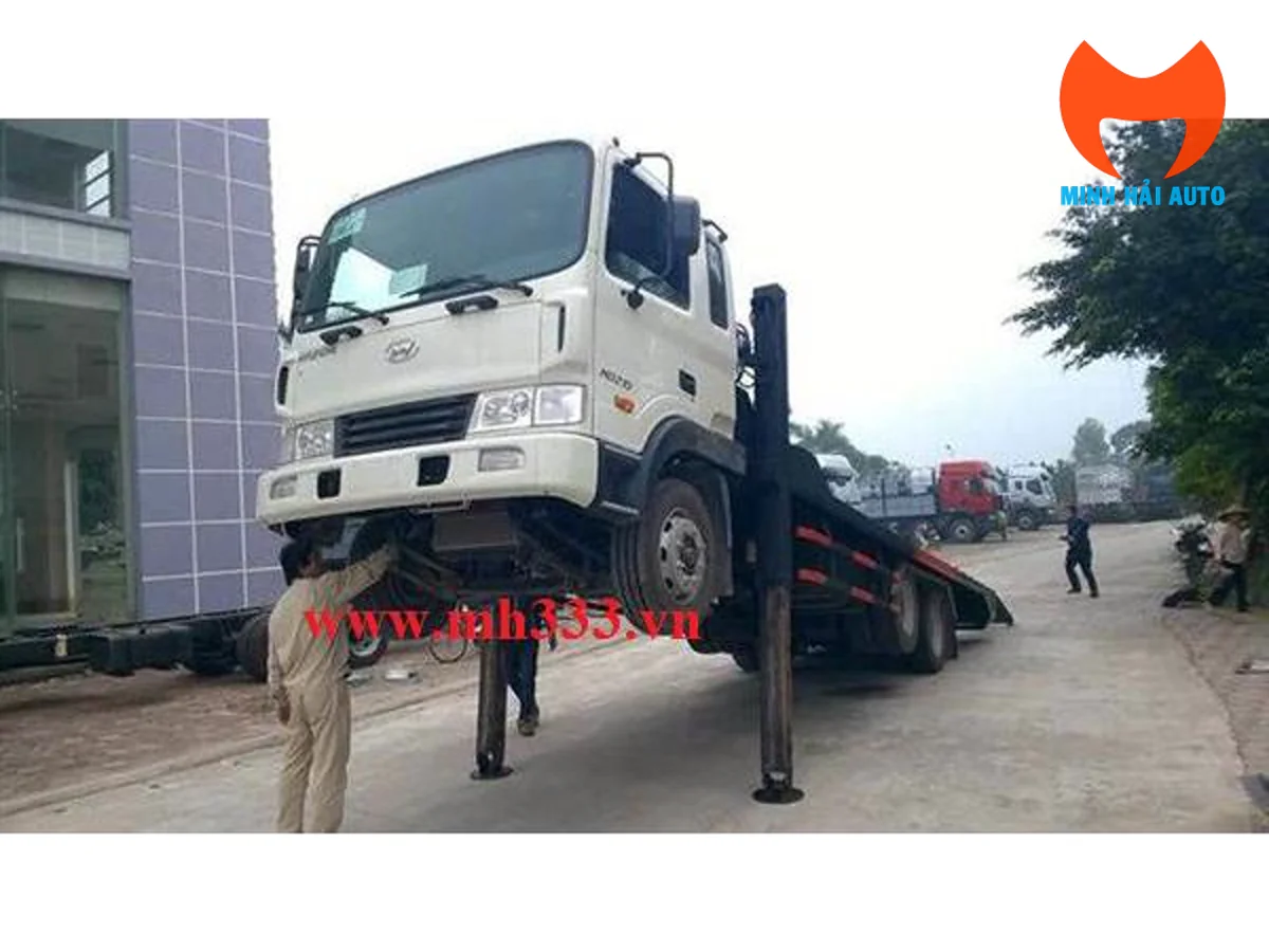 Hyundai HD210 chở máy công trình nhìn từ góc trước, cơ cấu nâng đầu đang triển khai