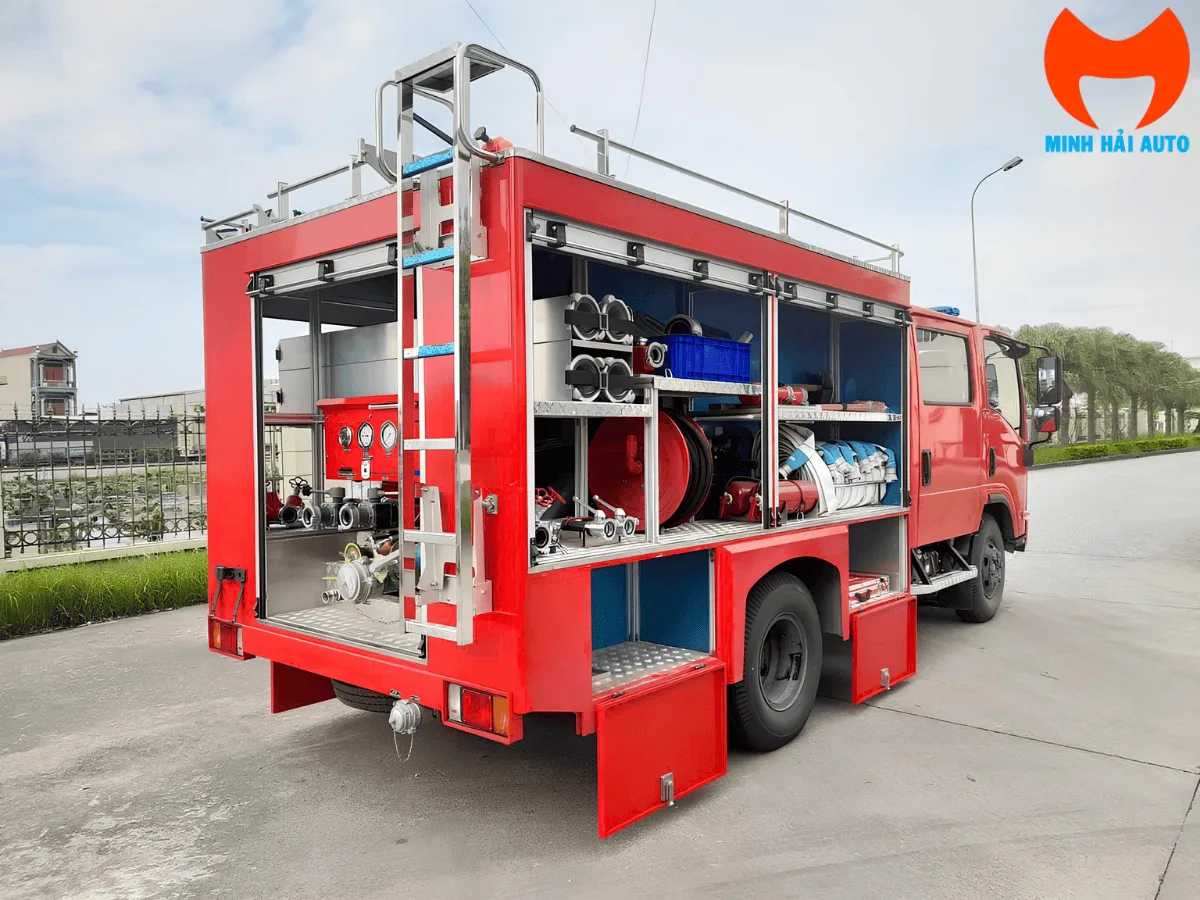 Khoang thiết bị phía sau xe cứu hỏa Isuzu mở cửa, thấy vòi, lăng và bảng đồng hồ bơm