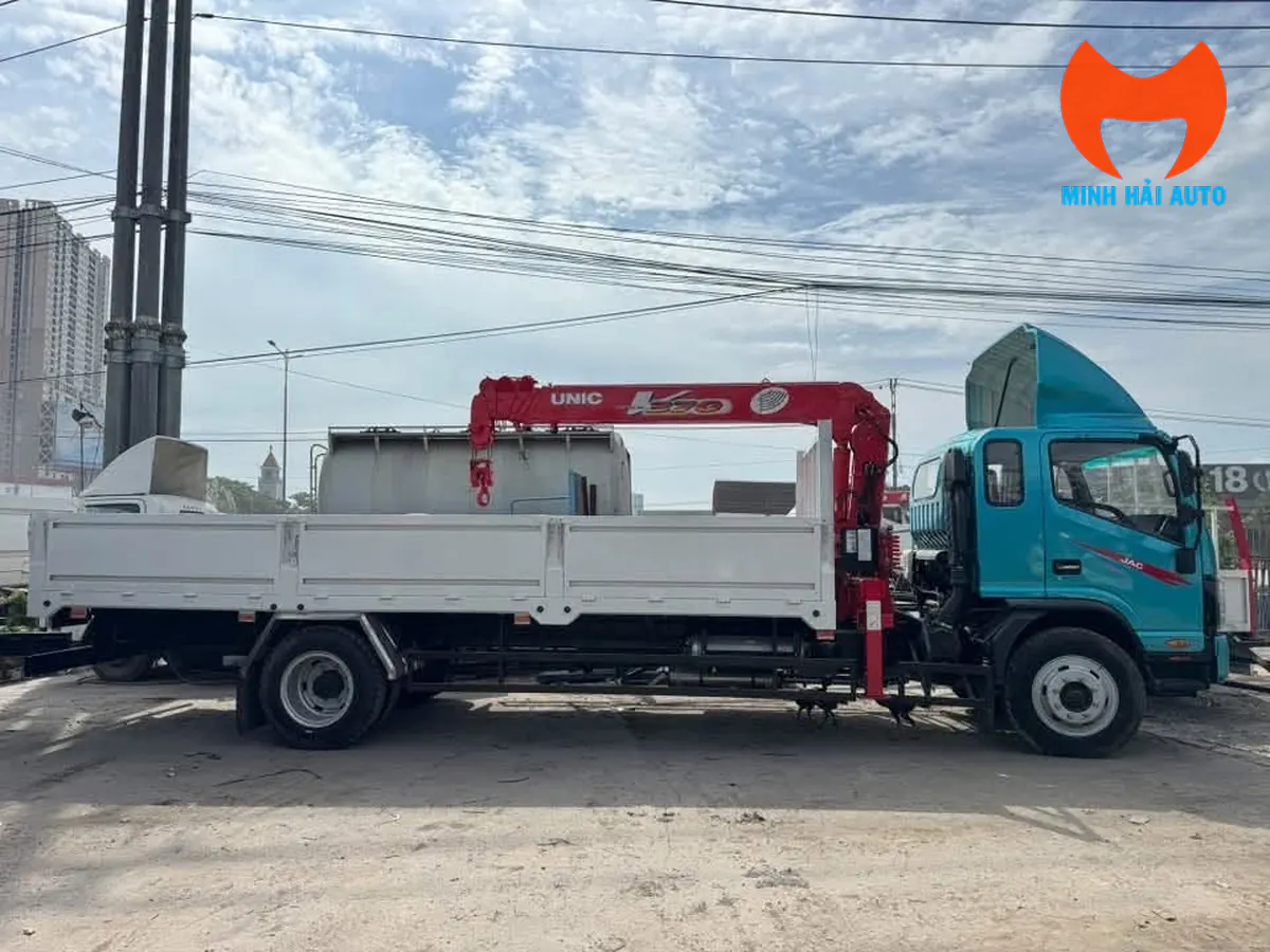 Xe JAC gắn cẩu UNIC nhìn ngang với thùng lửng màu trắng