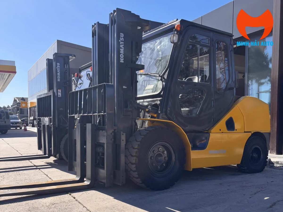 Xe nâng Komatsu FD50 nhìn từ góc trước với khung nâng và cặp càng
