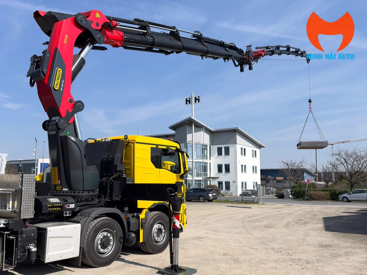 Xe MAN gắn cẩu gập Palfinger vươn cần và treo kiện hàng tại sân bãi