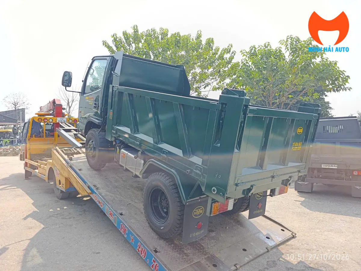 Xe tải ben Hoa Mai đặt trên bàn trượt nghiêng của xe chở chuyên dùng trong khu vực tập kết
