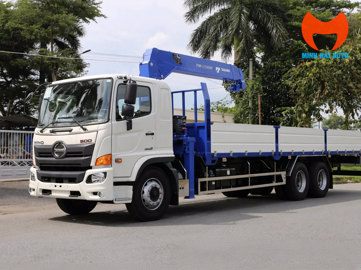 Xe tải Hino cabin trắng, thùng lửng trắng và cẩu cần thẳng màu xanh nhìn từ góc trước bên trái