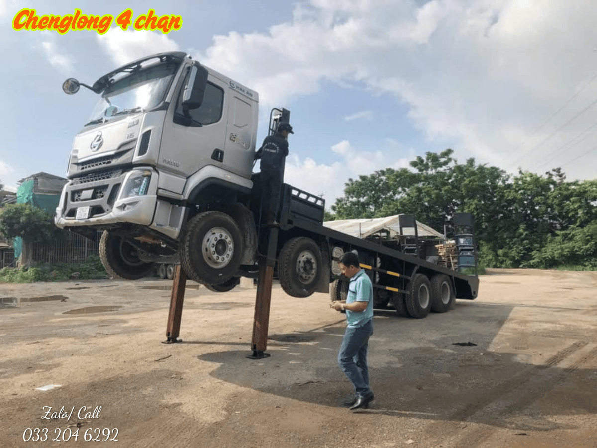 Xe chở máy chenglong 4 chân đang vận chuyển một máy xúc công trình.