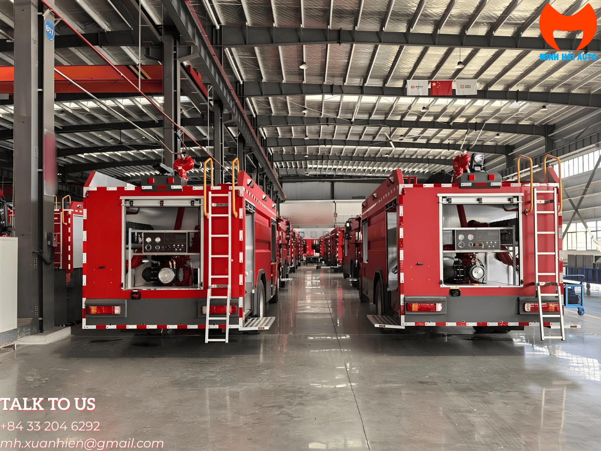 Xe chữa cháy Foton Auman 12000L với đèn cảnh báo đỏ và xanh bật sáng, phản chiếu trên sân trạm cứu hỏa vào ban đêm.