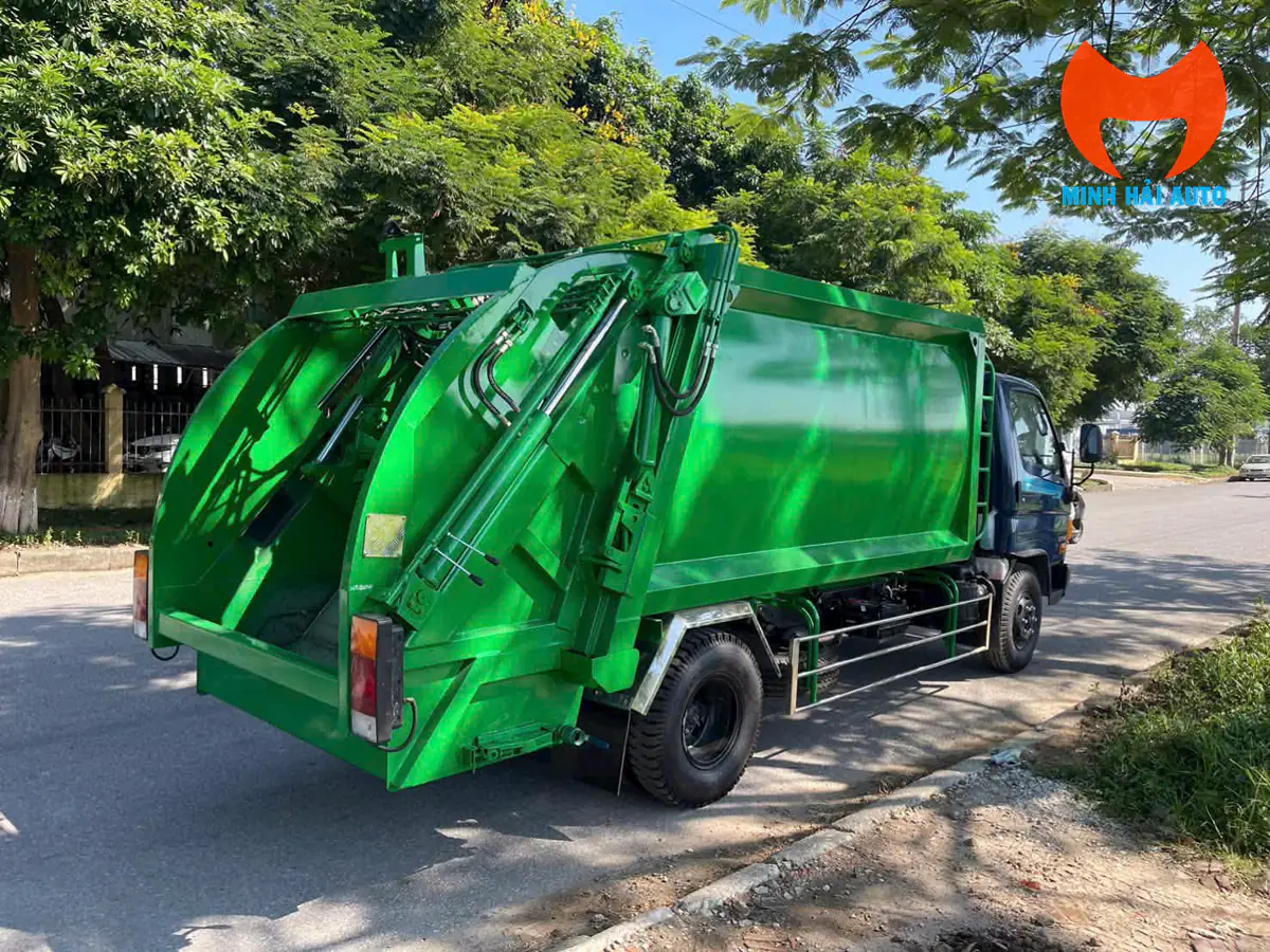 Cụm buồng cuốn ép phía sau xe cuốn ép rác Hyundai với máng nạp hở, hai tay trang thủy lực bên phụ và van xả nước rỉ rác ở đáy