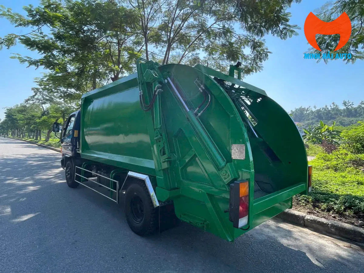 Góc sau bên lái xe cuốn ép rác Hyundai thể hiện vách thùng cong, chốt khóa cơ khí buồng đuôi và khoang thu nước rỉ dưới đáy máng nạp