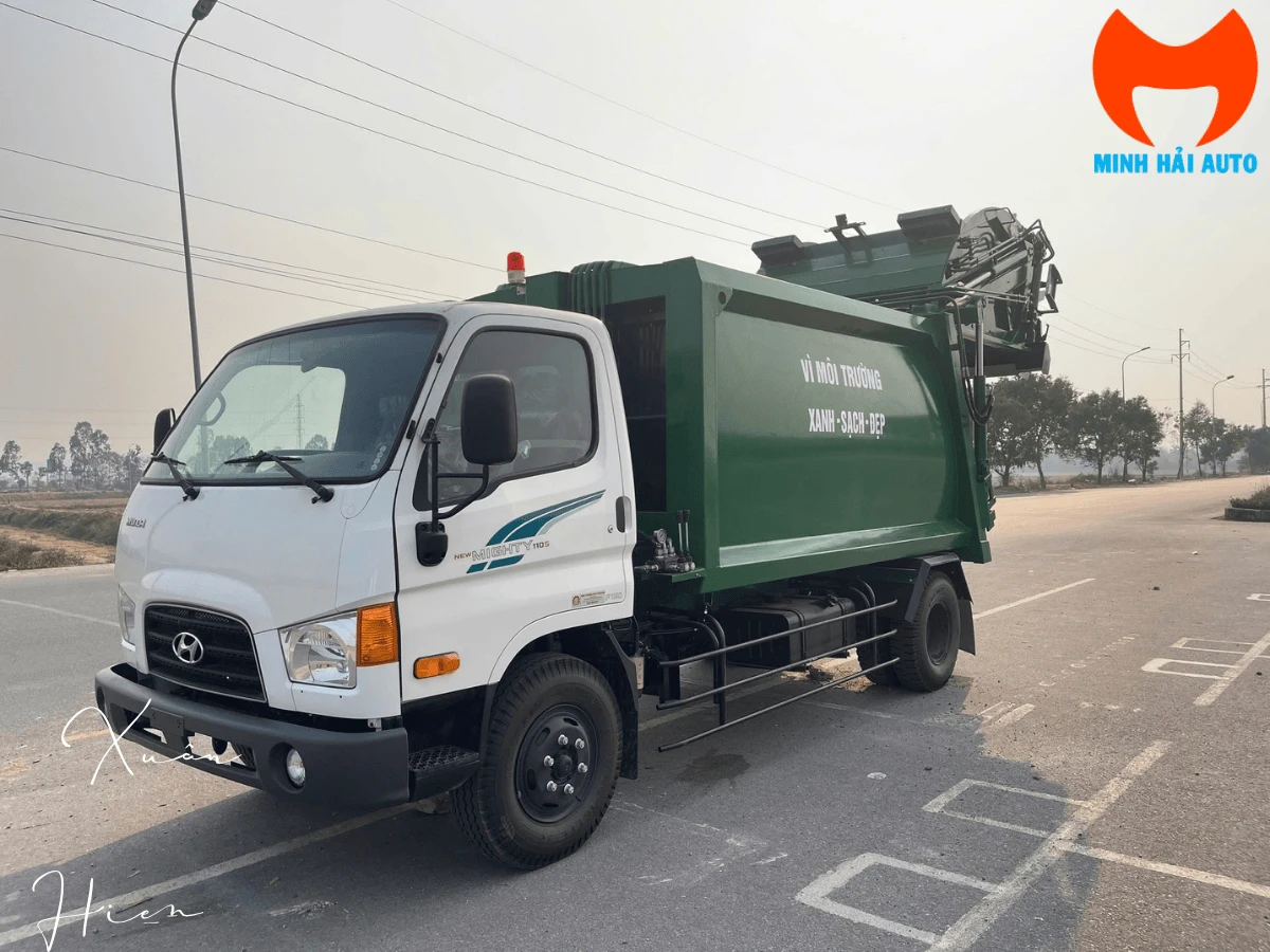 Xe ép rác Hyundai 110SP 9 khối nhìn góc ba phần tư phía trước, cabin trắng New Mighty 110S và thùng ép sơn xanh lá