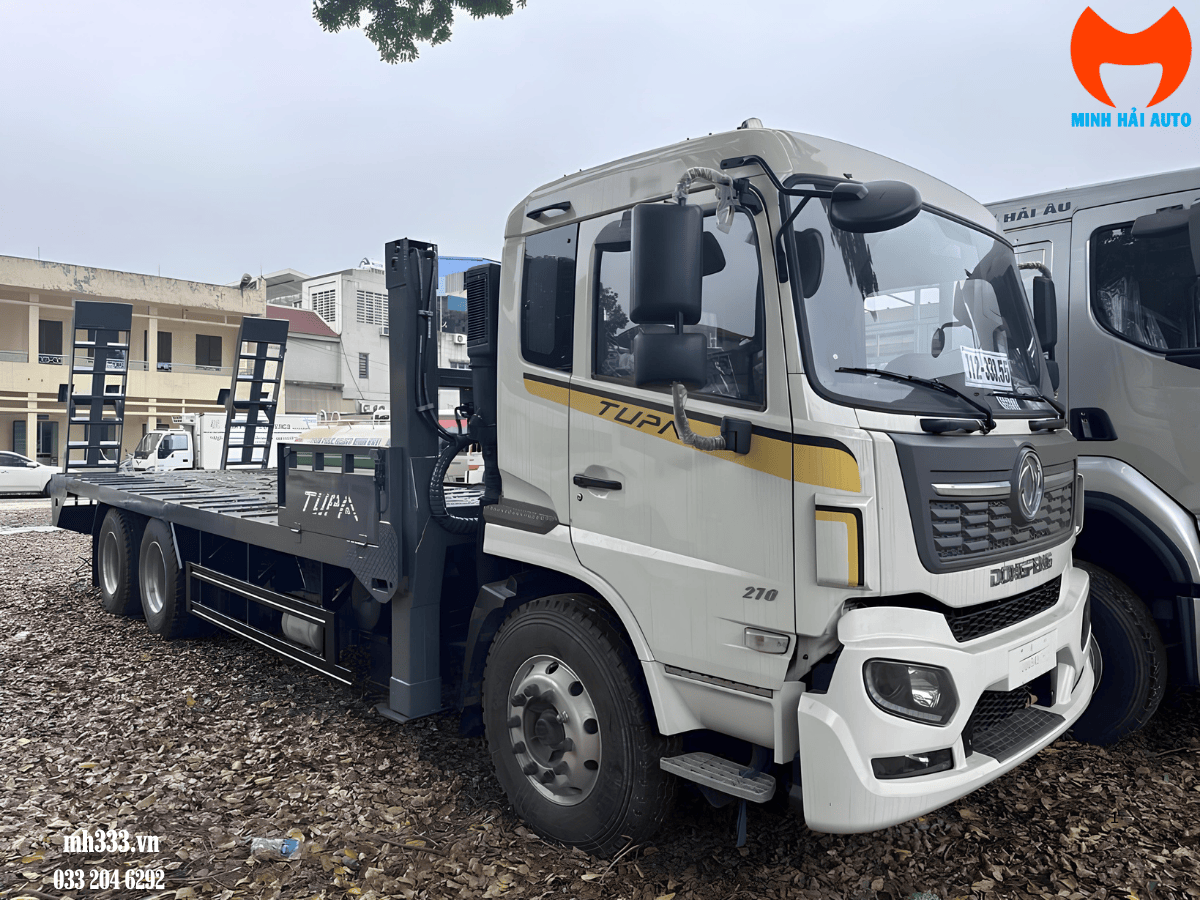 Xe nâng đầu chở máy Dongfeng 3 chân đang vận chuyển một chiếc máy xúc lật trên đường.