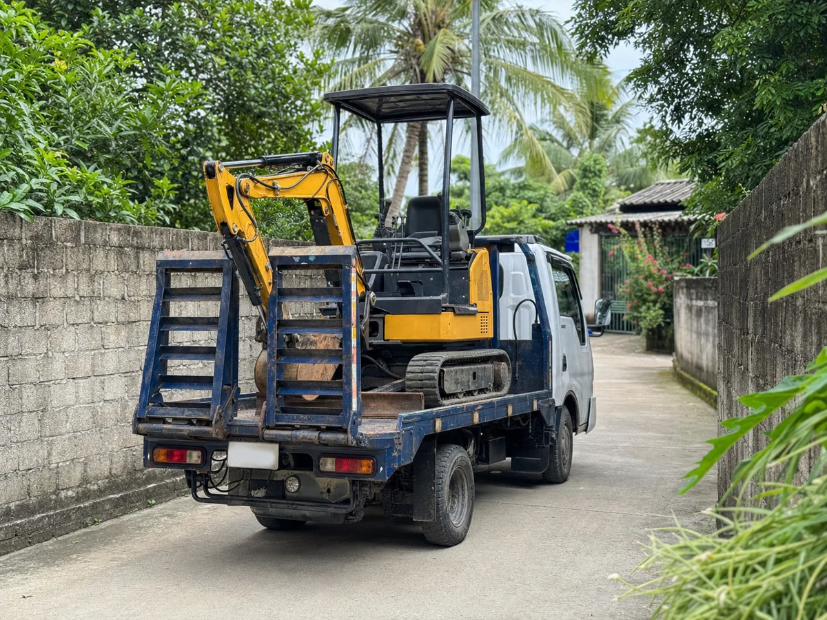 Xe nâng đầu tải nhẹ chở máy xúc mini đi vào đường bê tông hẹp