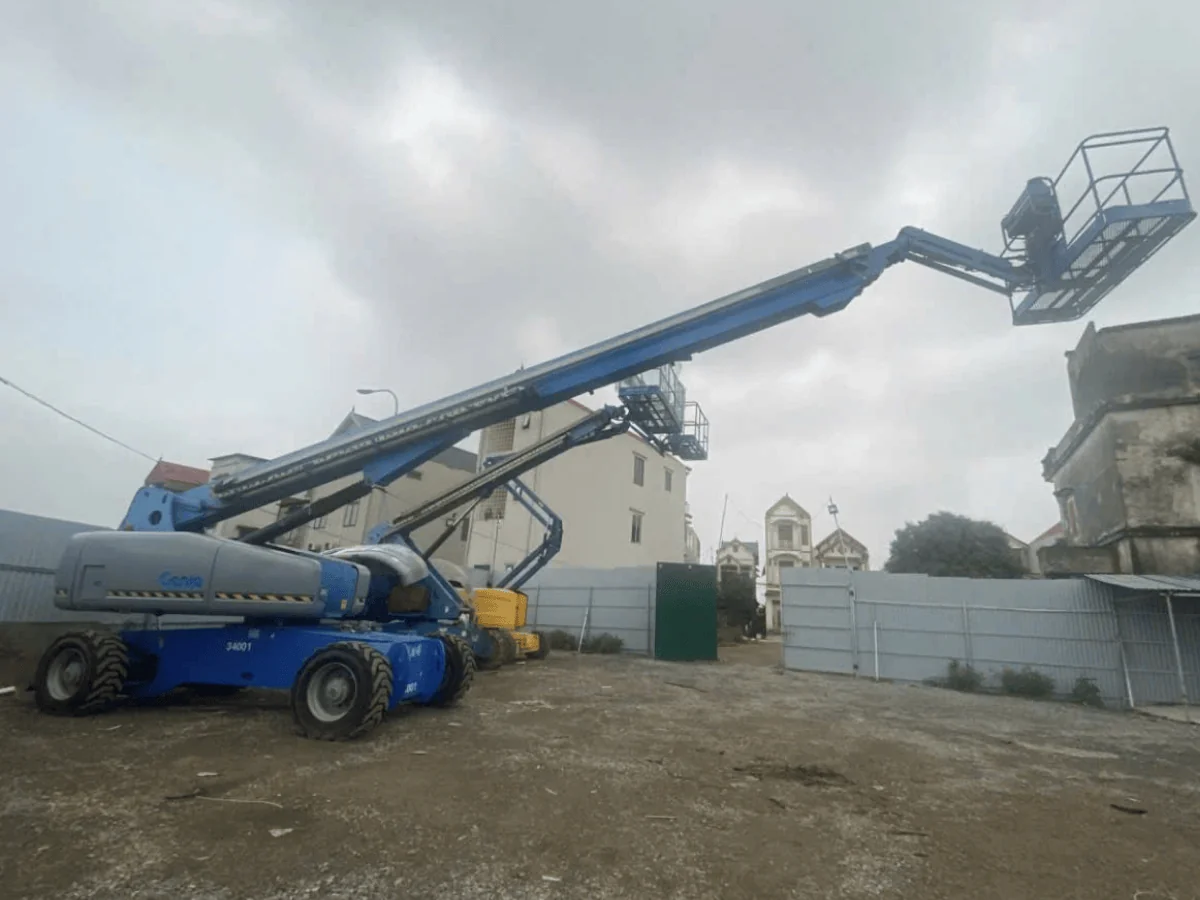 Xe nâng người cần khớp gập màu xanh ở tư thế nâng giỏ
